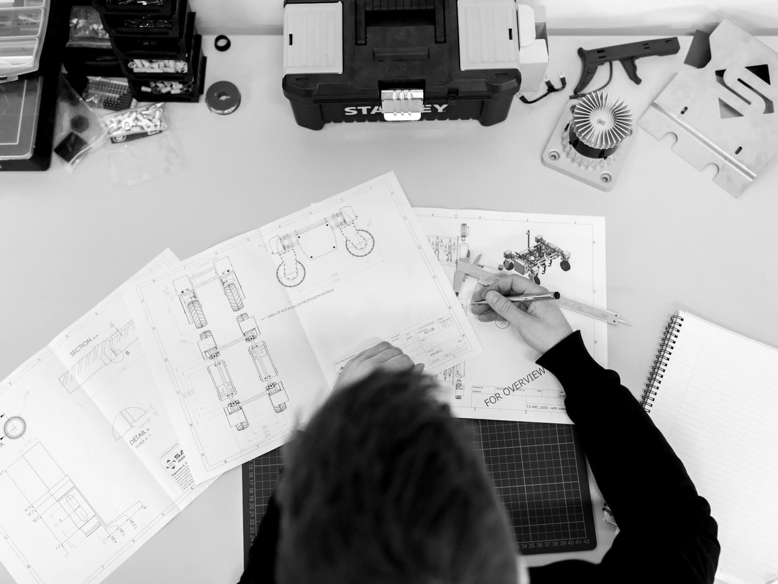 Engineer measuring technical drawings with calipers